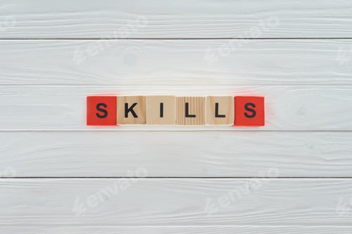 Preview: top view of skills inscription made of blocks on white wooden surface