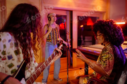 Preview: Portrait of a hispanic woman producer working with a band in a music studio
