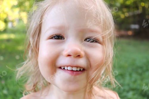 Preview: close-up of a happy smiling face of a little blonde girl