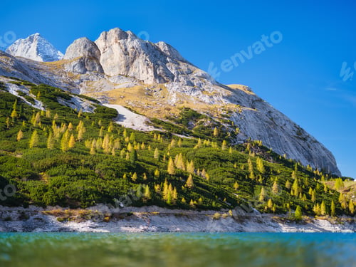 Preview: High mountains with forest and reflection on the surface of the lake.