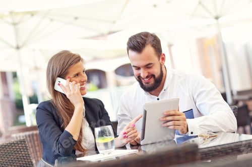 Preview: Business Associates Talking on Tablet and Smartphone