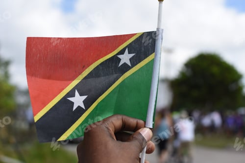 Preview: Hand holding a flag of Saint Kitts and Nevis
