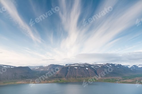 Preview: fjord surrounded by beautiful mountgains bathing in evening light
