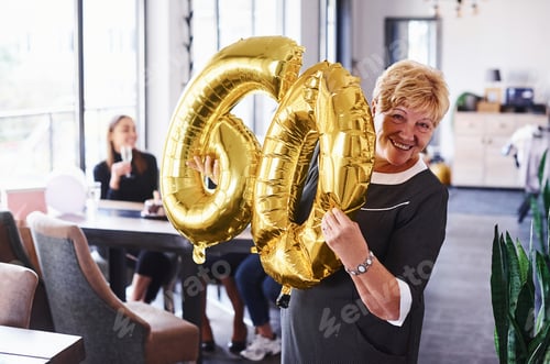 Preview: Senior woman with family and friends celebrating a birthday indoors