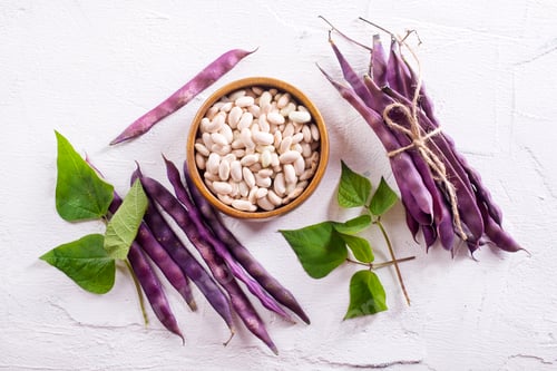 Preview: Uncooked dried white haricot beans in bowl n on table. Heap of legume haricot bean background