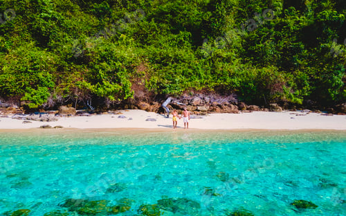 Preview: a couple walking at the beach of Koh Kradan Island in Thailand