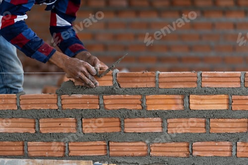 Preview: Bricklayer Working on a New Wall in City