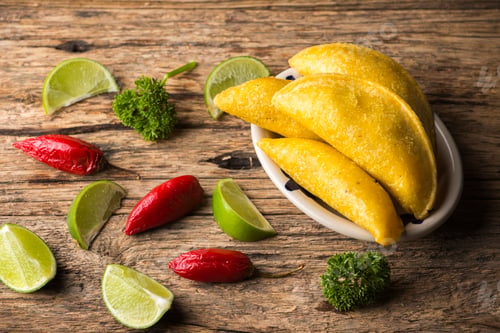 Vista previa: Empanadas and hot pepper on wooden background, traditional Colombian food