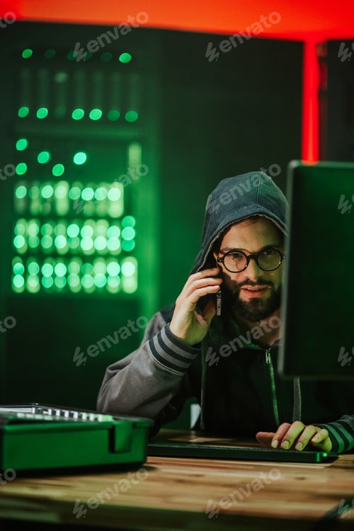 Preview: Hacker talking on phone in dark server room