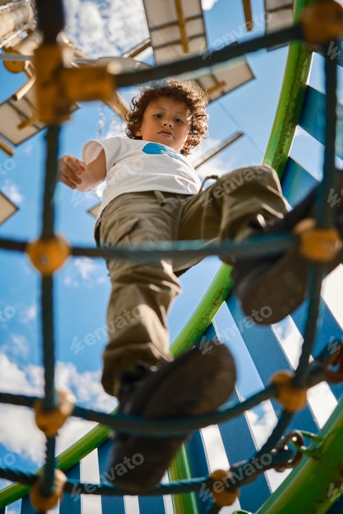 Preview: Child walking on a net of ropes on a sunny day