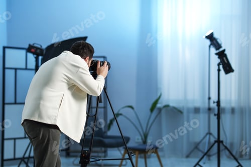 Preview: Man with professional video camera in studio. Space for text