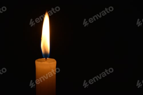 Preview: Closeup of a lit candle in the dark
