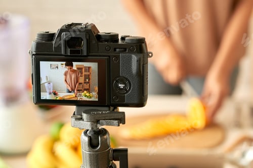 Woman Slicing Fruit Recording Video In Bright Kitchen