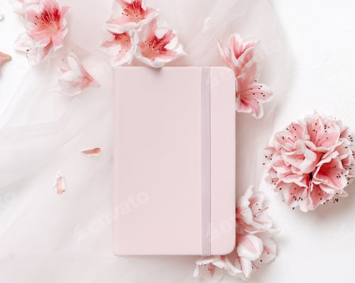 Preview: Blank vertical paper card near pink azalea flowers and ribbons top view, spring wedding mockup