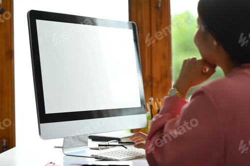Preview: Side view of female employee working on new project at workplace.