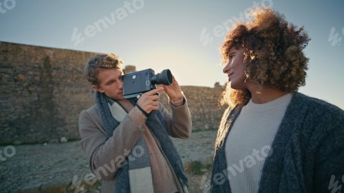 Preview: Romantic couple taking pictures on camera at rocky shore closeup. Woman posing