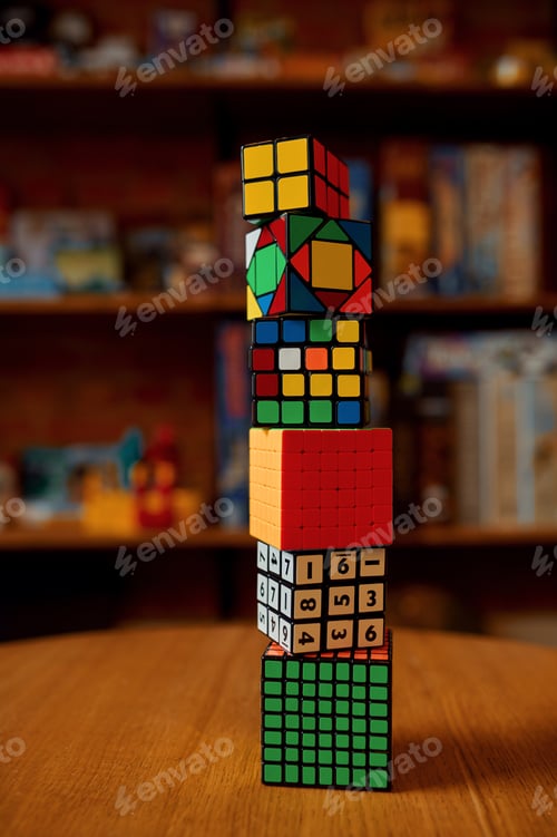 Preview: Tower of colorful puzzle cubes on table, nobody