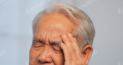 Preview: Asian old man with migraine headache. Elderly man suffering from a headache.