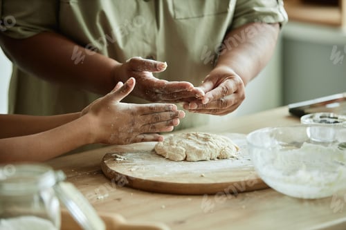 Preview: Black Woman and Young Girl Cooking Dough on Kitchen Counter