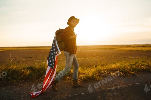Preview: 4th of July. American Flag. Traveler with the flag of America. The man in a hat, a backpack.