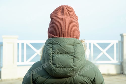 Preview: Woman sitting on bench on embankment with amazing view on sea