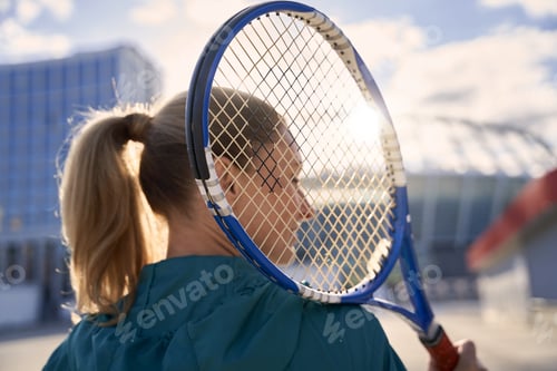 Preview: Close up shot of sportswoman, professional tennis player standing with tennis racket outdoors