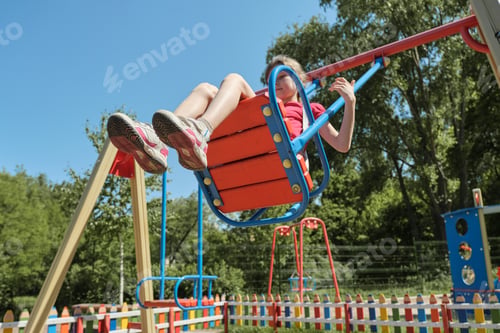 Preview: Girl child riding on swing, sunny summer day