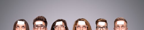 Preview: People with stickers on foreheads behind banner