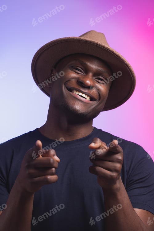 Preview: African american man wearing hat pointing to you and camera with fingers, smiling positive and