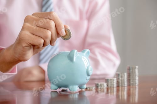 Preview: Businessman hand putting coin into blue piggy bank