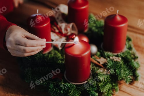 Preview: Human hand lighting the first candle on Advent Wreath, old swiss tradition in December to count days