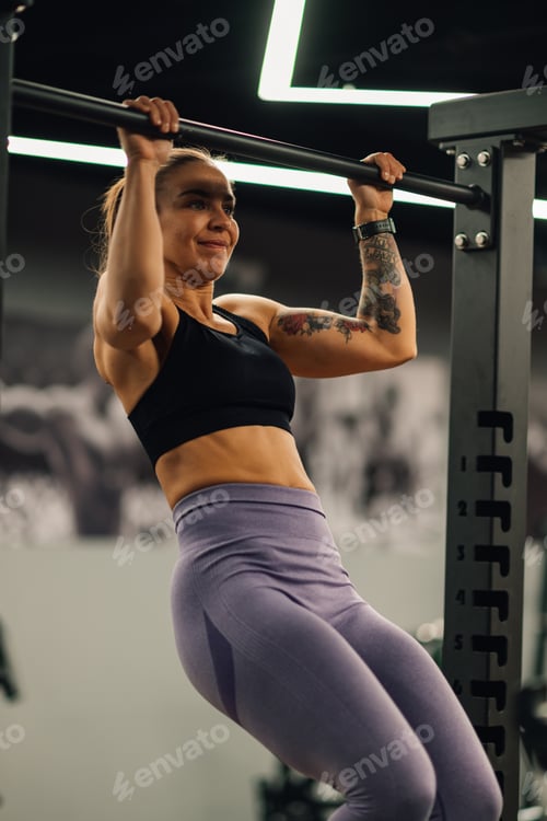 Preview: Determined sportswoman performing pull ups during cross training workout
