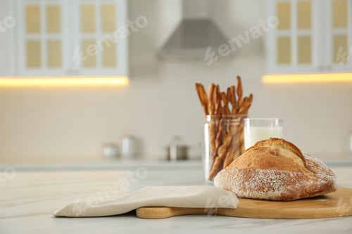 Preview: Loaf of bread on white table in kitchen. Space for text