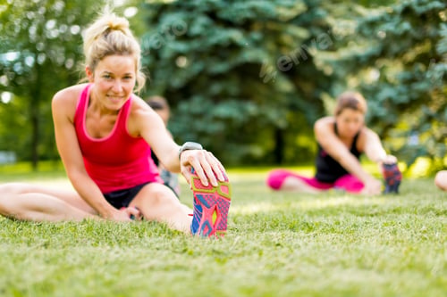 Preview: young woman stetching before a jog