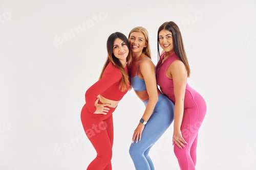 Preview: Standing and smiling. Beautiful women in sportive clothes is indoors in the studio
