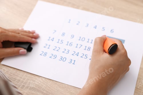 Preview: Business planning. Woman using calendar at wooden table in office, closeup
