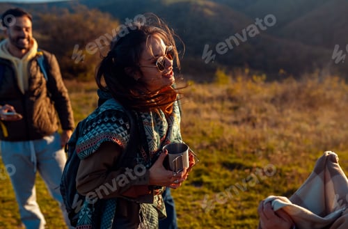 Preview: Portrait of a woman on hiking with friends holding a tea cups.