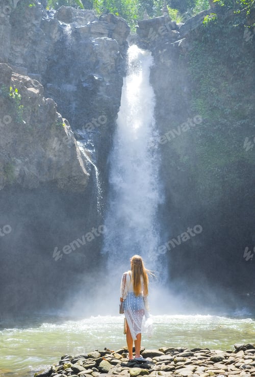 Preview: A girl on the background of a mountain waterfall