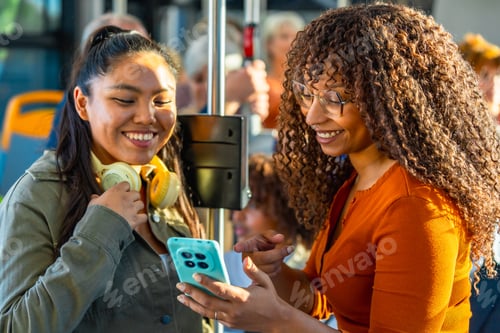 Preview: Diverse women friends sharing smartphone on bus