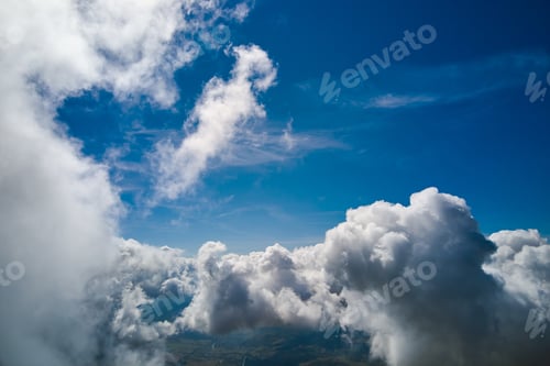 Preview: Aerial view from airplane window at high altitude of earth covered with puffy cumulus clouds forming