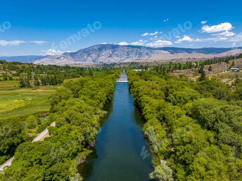 Preview: View of channel near vineyards in Oliver, British Columbia, Canada with valley and mountain cliffs