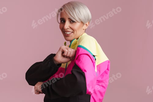 Preview: White-haired woman wearing multicolored jacket smiling and dancing
