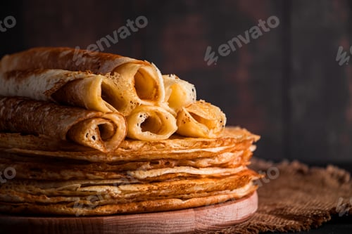 Preview: Thin pancakes on a plate on a black background. Traditional Russian food.