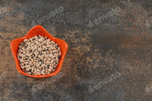 Preview: Heap of dry white beans in orange bowl