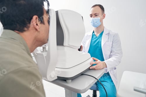 Preview: Male doctor working at the refraction machine