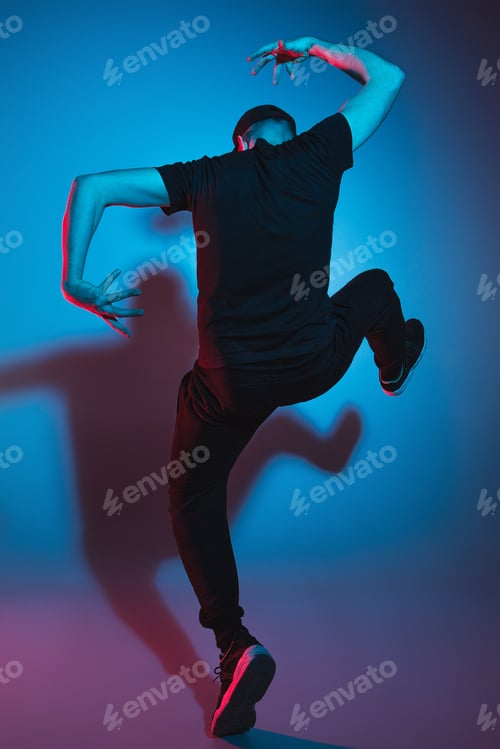 Preview: The silhouette of one hip hop male break dancer dancing on colorful background