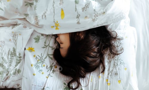Preview: Woman Sleeping Peacefully in Bed with Floral Sheets