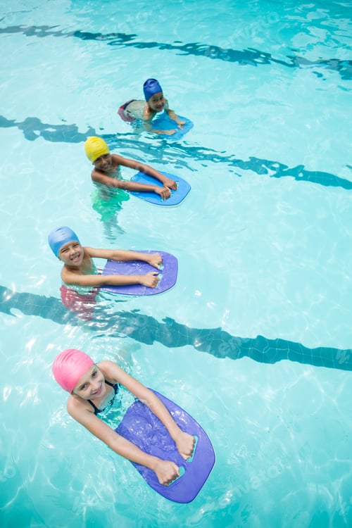 Preview: Children using kickboard while swimming in pool