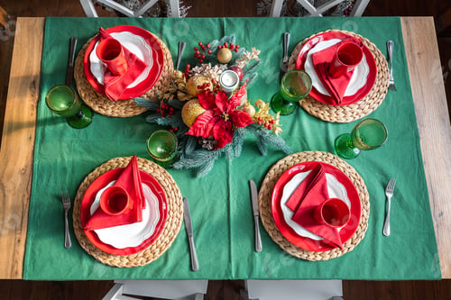 Preview: Flat lay view of festive holiday xmas family table setting served for 4 persons with light