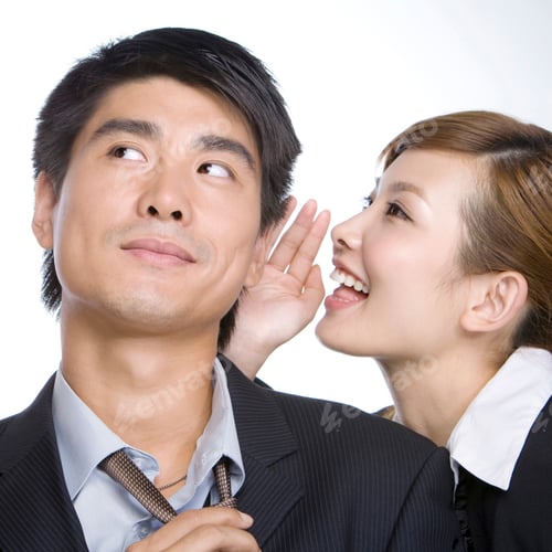 Preview: Young businesswoman whispering by businessman's ear